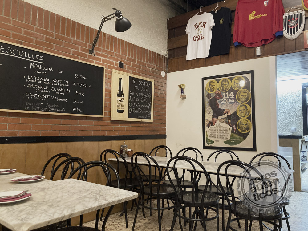 Dining room with marble tables, wine chalkboard and Bar Gol t-shirts on the wall