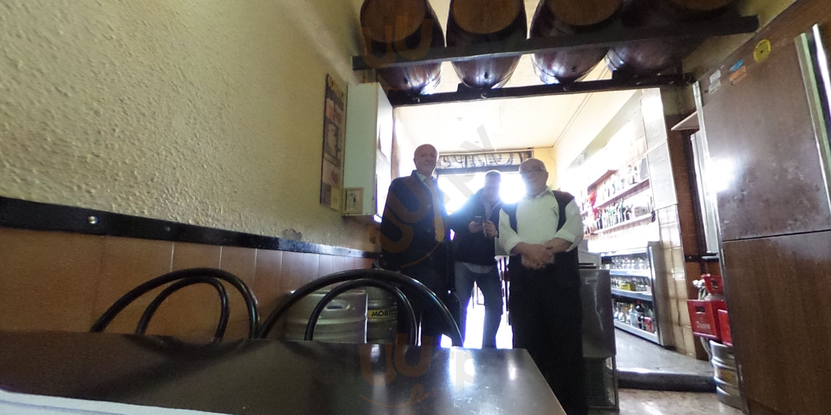 Old bar interior with hanging wine barrels, tiled walls